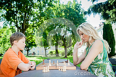 mother-son-playing-chess-park-32358815